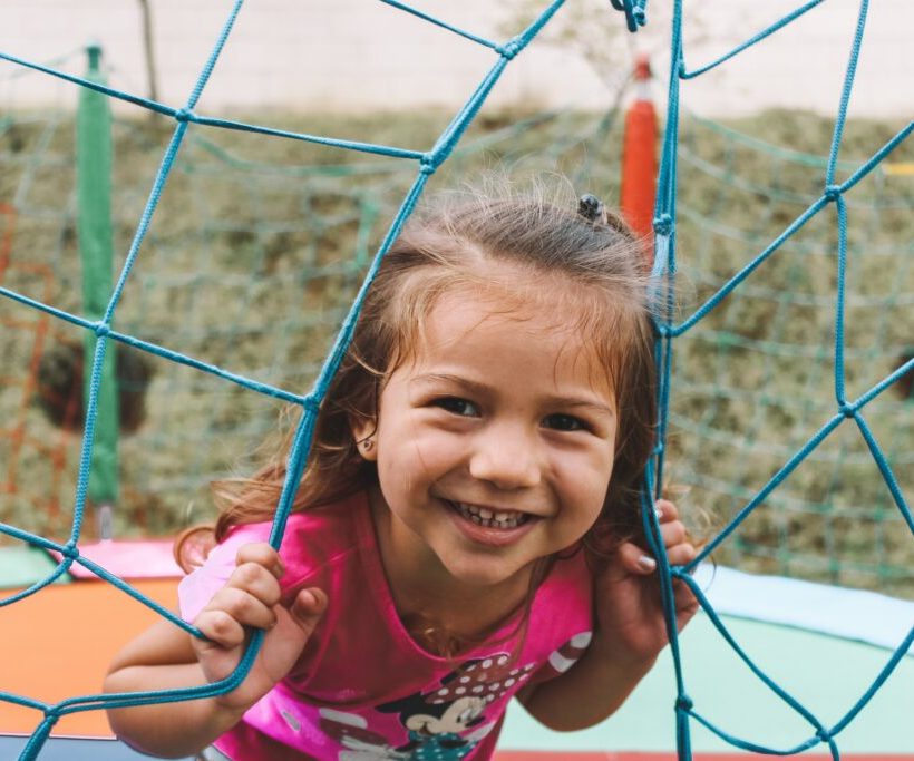 image of a smiling young girl playing on a trampoline