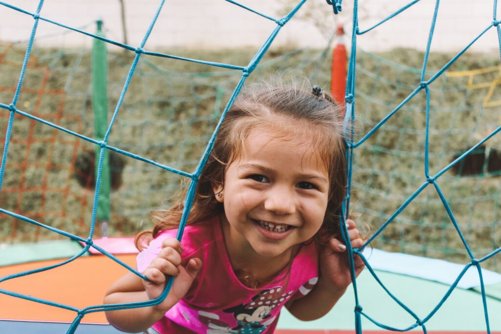 image of a smiling young girl playing on a trampoline